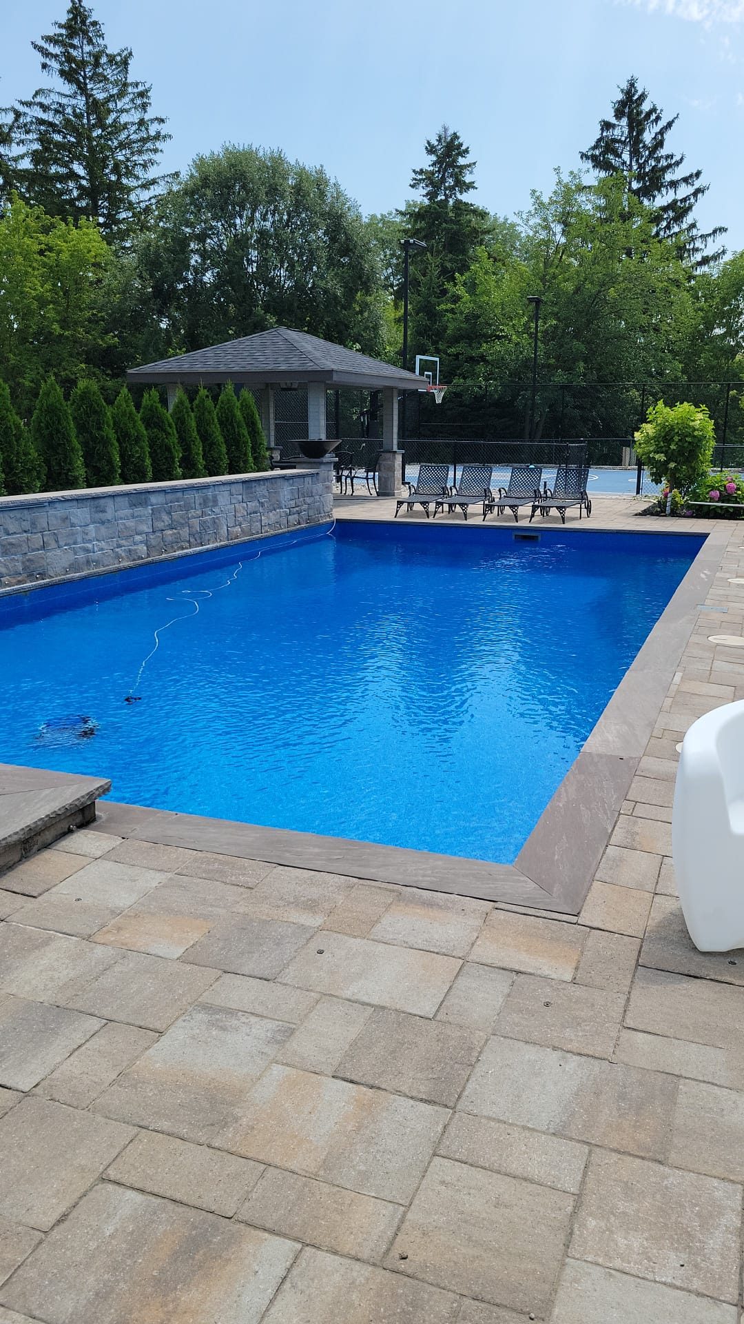 Aluminum pool fencing with self-closing gate installed around a backyard pool in Richmond Hill